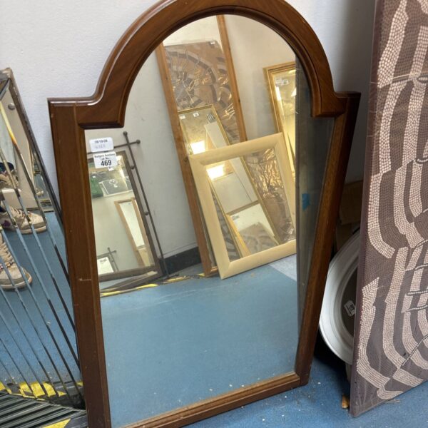 Vintage arch topped mirror with wooden frame for wall decoration.