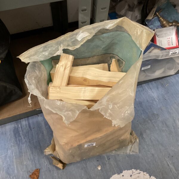Bag of loose pale wooden blocks and legs in a torn bag