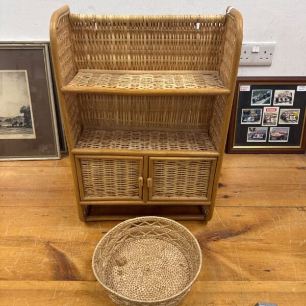 Vintage bamboo shelf unit with woven basket for rustic storage.