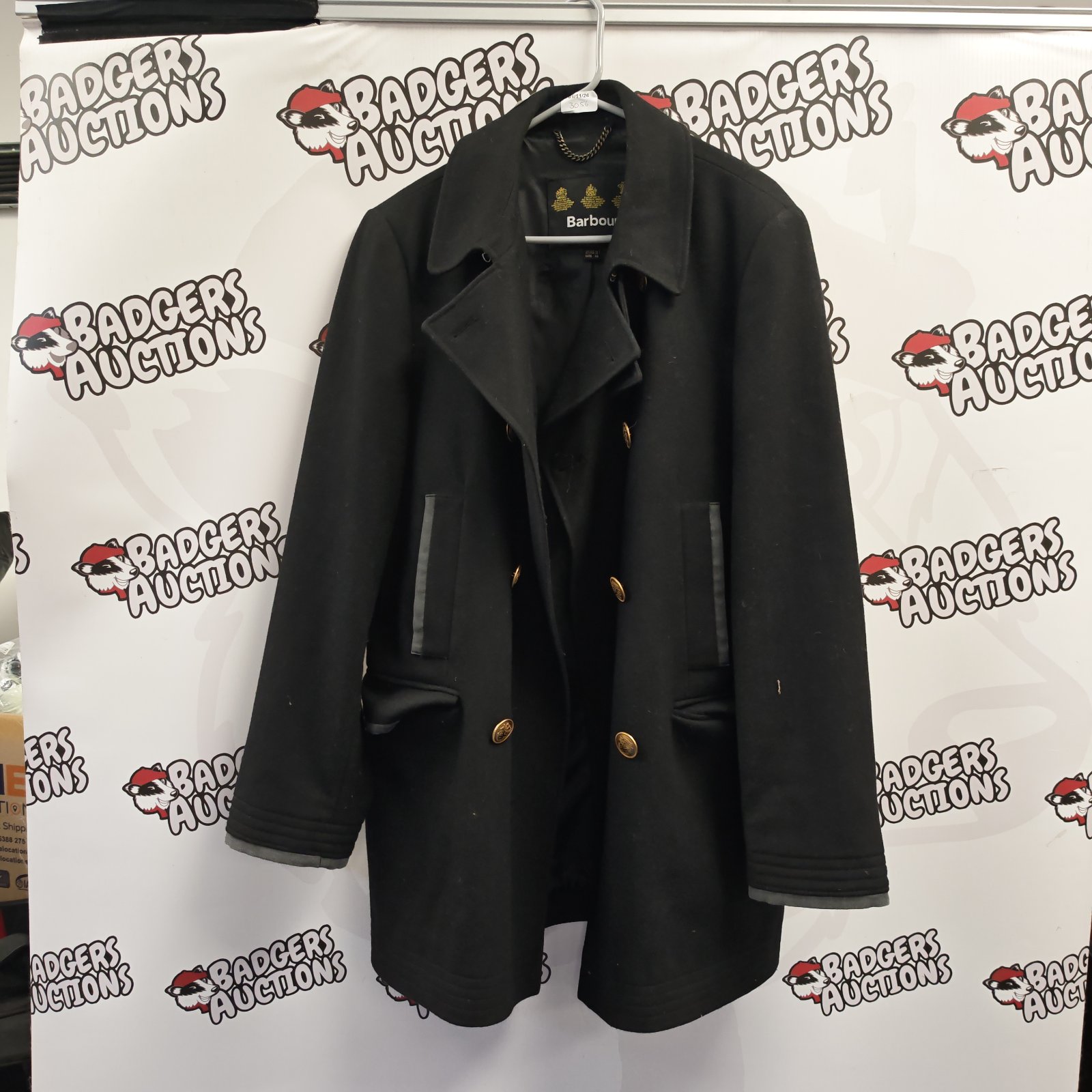 Black Barbour ladies double-breasted coat with gold-tone buttons on hanger