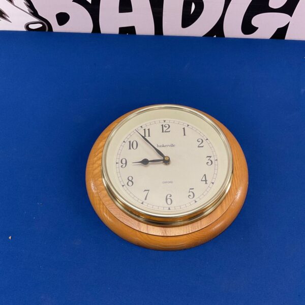 Vintage Baskerville Oxford wall clock with wooden frame.
