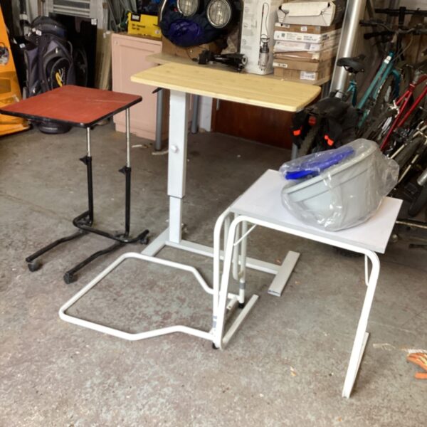 Adjustable bed table with laminate top and castors.