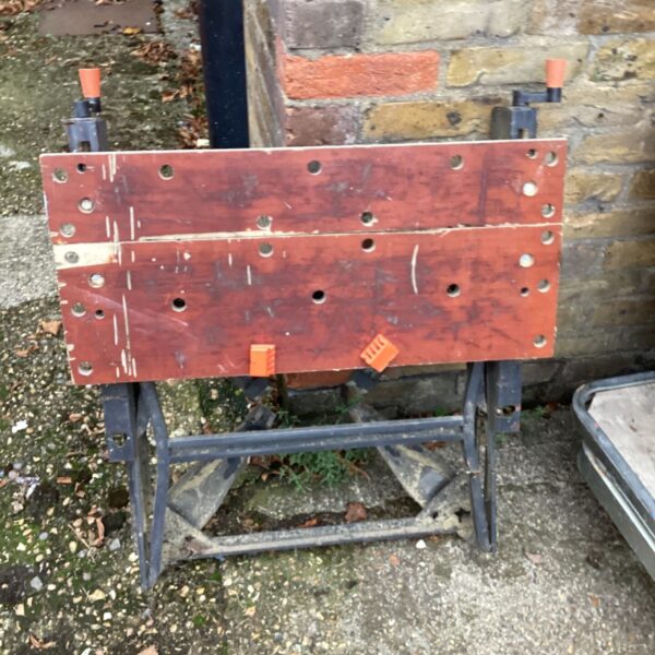 Black and Decker Workmate portable workbench with red work surface and orange clamps