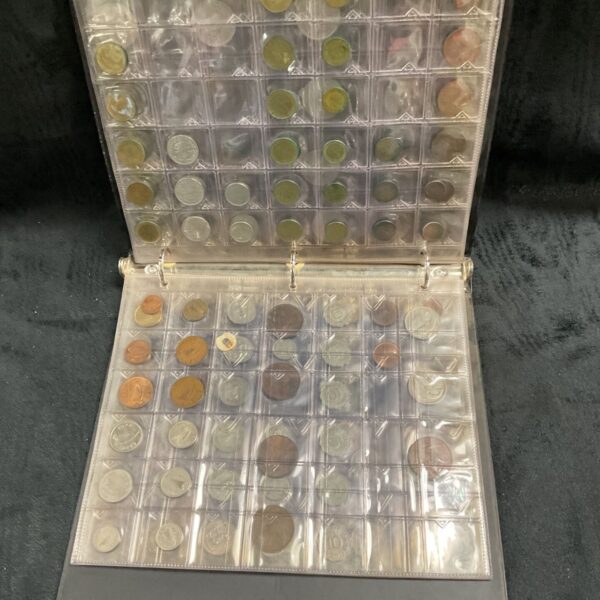 Open black coin folder displaying mostly overseas coins in clear plastic pockets