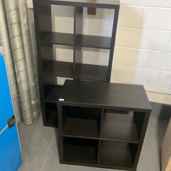Pair of black open cubic shelving units standing on a grey floor