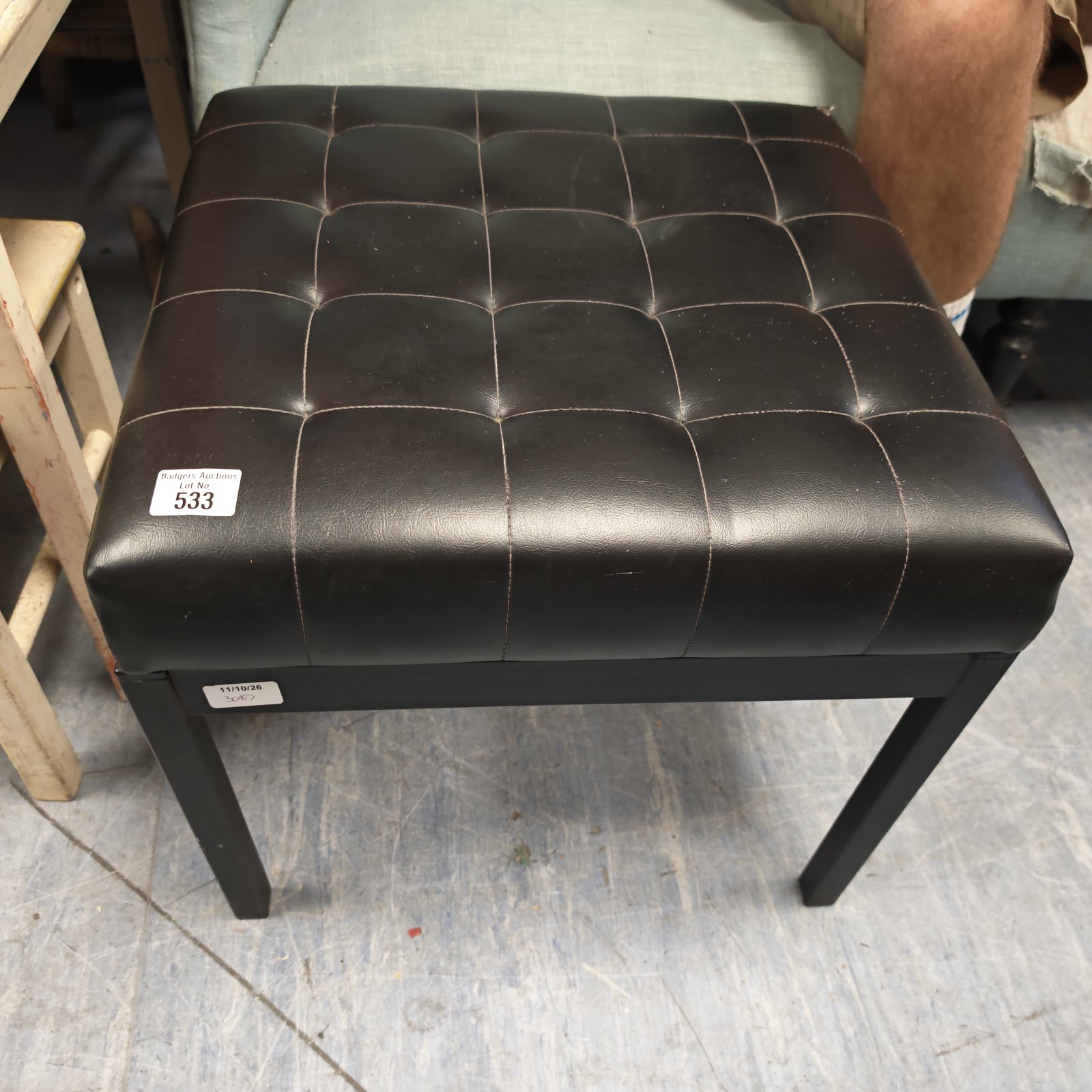 Black leather topped stool with wooden legs, vintage style.