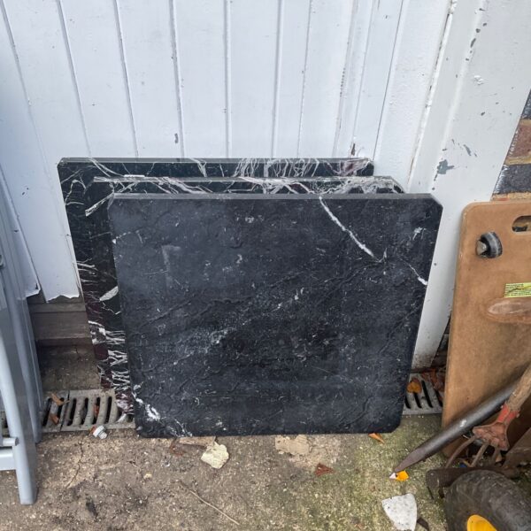 Black marble table top with grey veining, vintage stone surface.