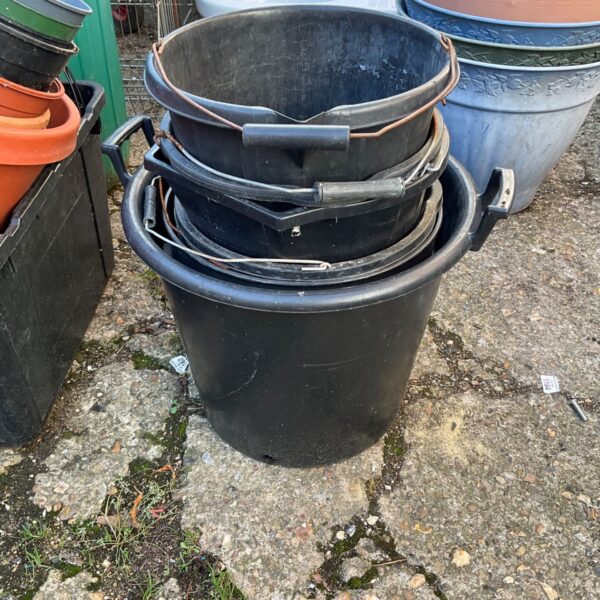 Black plastic buckets and tub for garden storage and utility.
