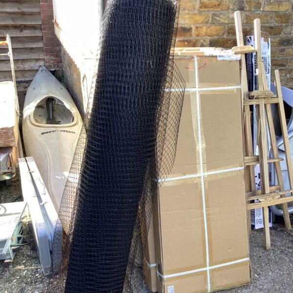 Roll of black plastic mesh for garden or construction use.