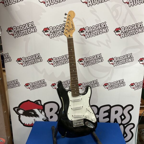 Black Squier mini electric guitar with white pickguard and dark fretboard