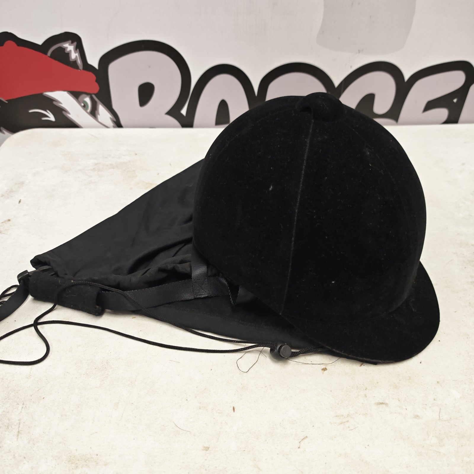 Black velvet equestrian riding helmet with attached black drawstring carry bag