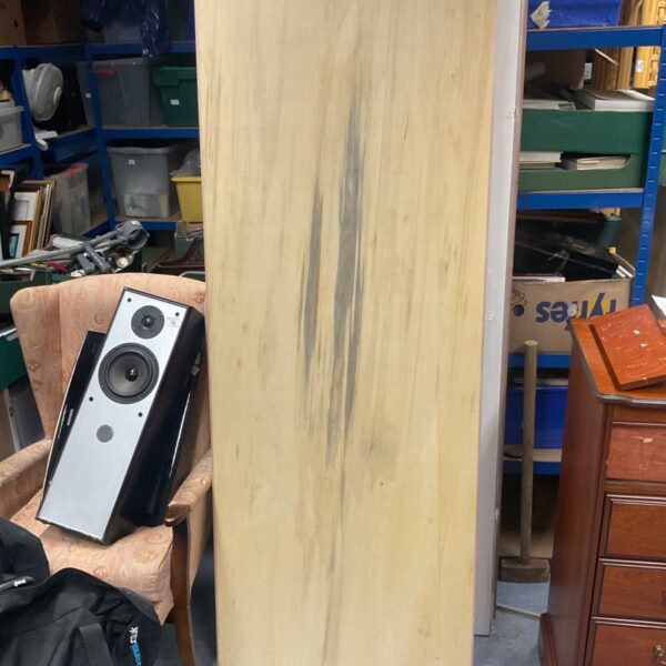 Pale timber-effect 78x30" blockboard door leaning against a wall