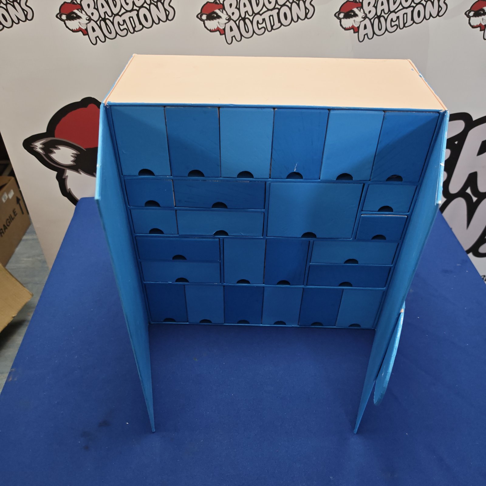 Blue painted wooden advent calendar with twenty-four drawers.