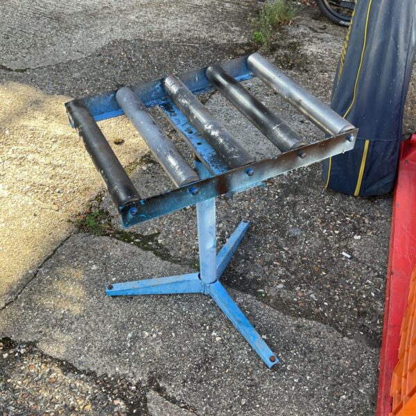Blue adjustable roller conveyor stand for workshop use.