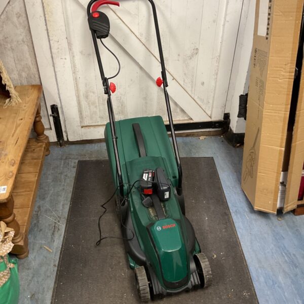 Green Bosch cordless mower with battery and charger visible.