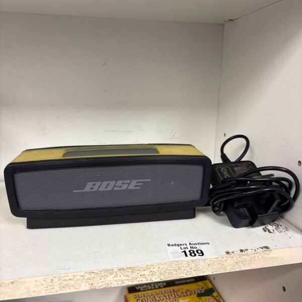 Yellow Bose SoundLink Mini Bluetooth speaker with charger included.