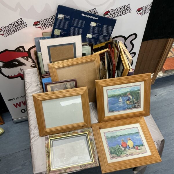 Box lot of mixed prints and wooden picture frames on a table