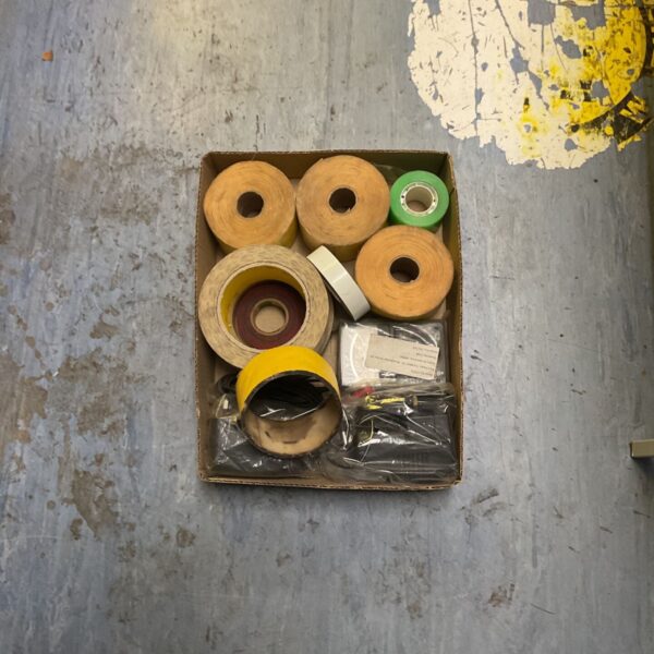 Cardboard box containing mixed adhesive tape rolls and loose cabling