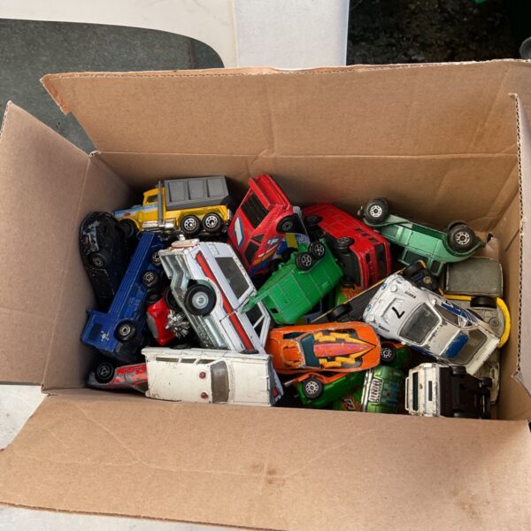 Cardboard box filled with assorted diecast model cars and trucks