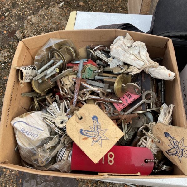 Cardboard box filled with loose mixed keys, lock bodies and tagged bundles