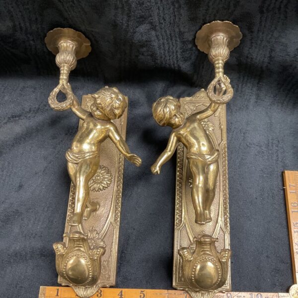 Antique brass putti wall sconces, a charming pair of cherub candle holders.
