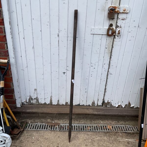 Rusted breaker bar leaning against a white door.