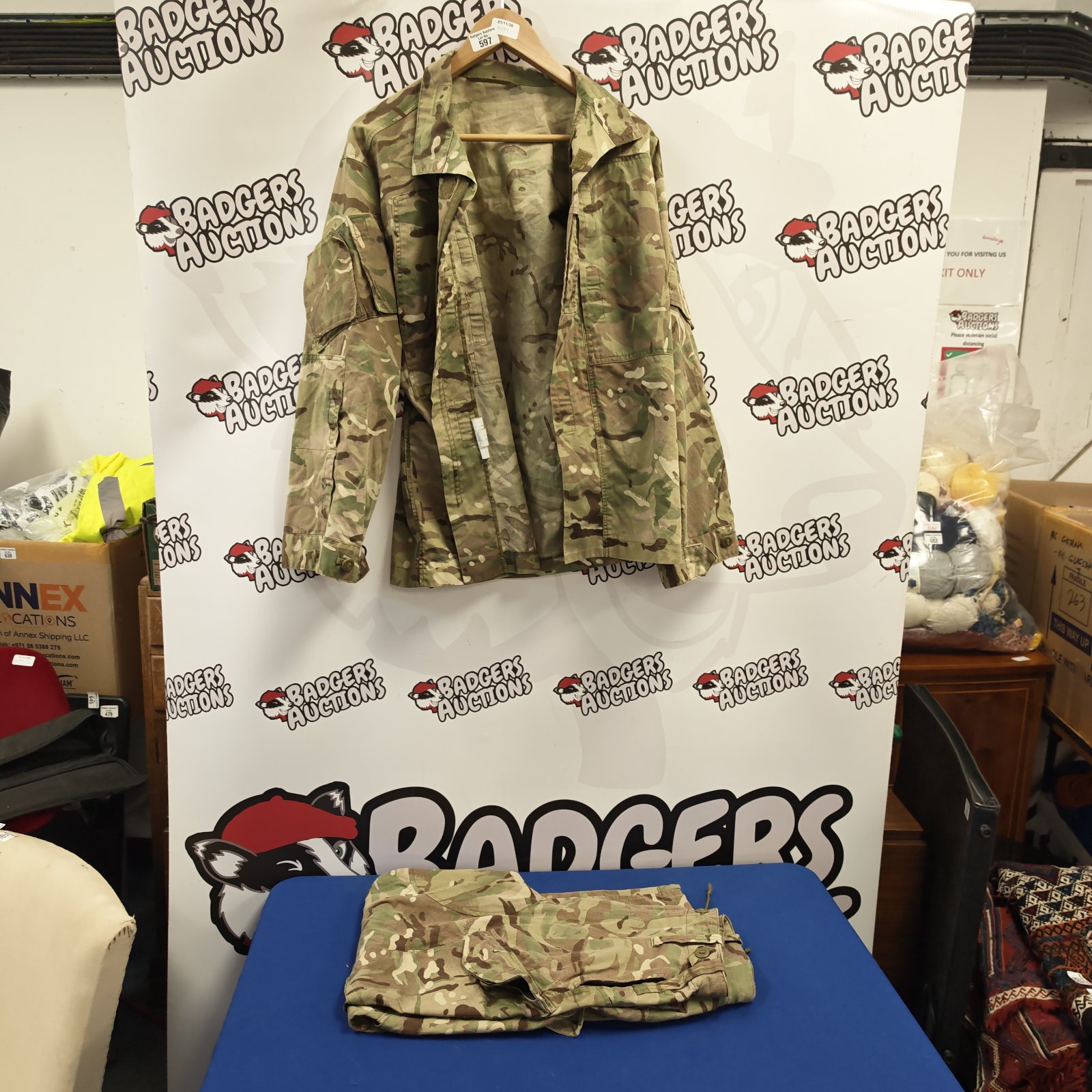 British Army MTP camouflage combat jacket hanging beside folded matching trousers