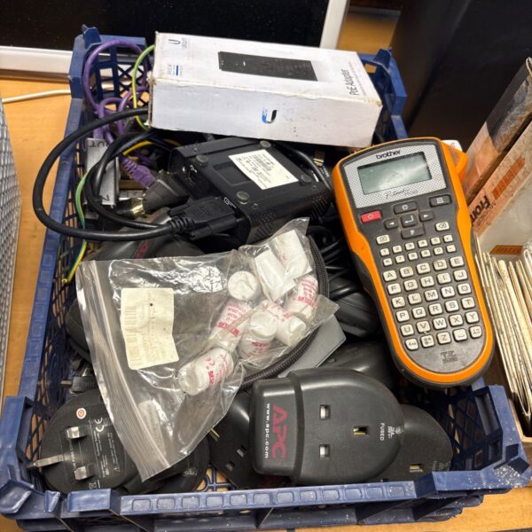 Blue crate of mixed electronics with Brother P-touch label printer and APC plug adaptors