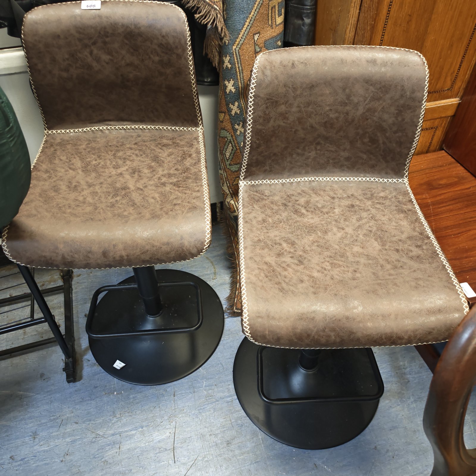 Pair of brown leather bar stools with chrome bases.