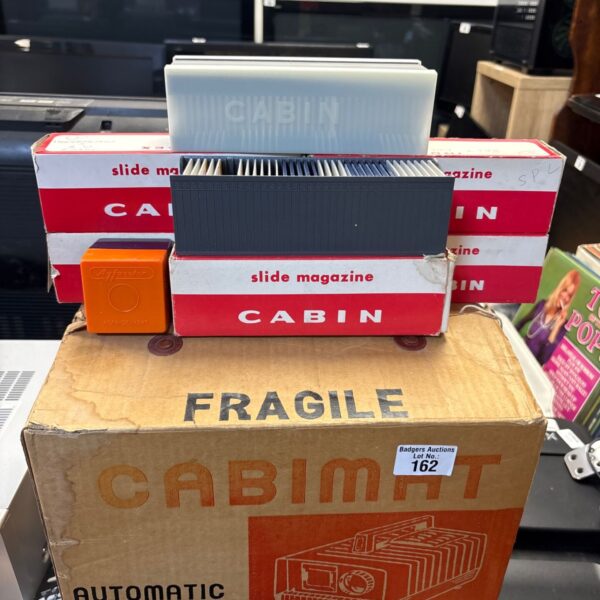 Vintage Cabimat slide projector with slides in original packaging.