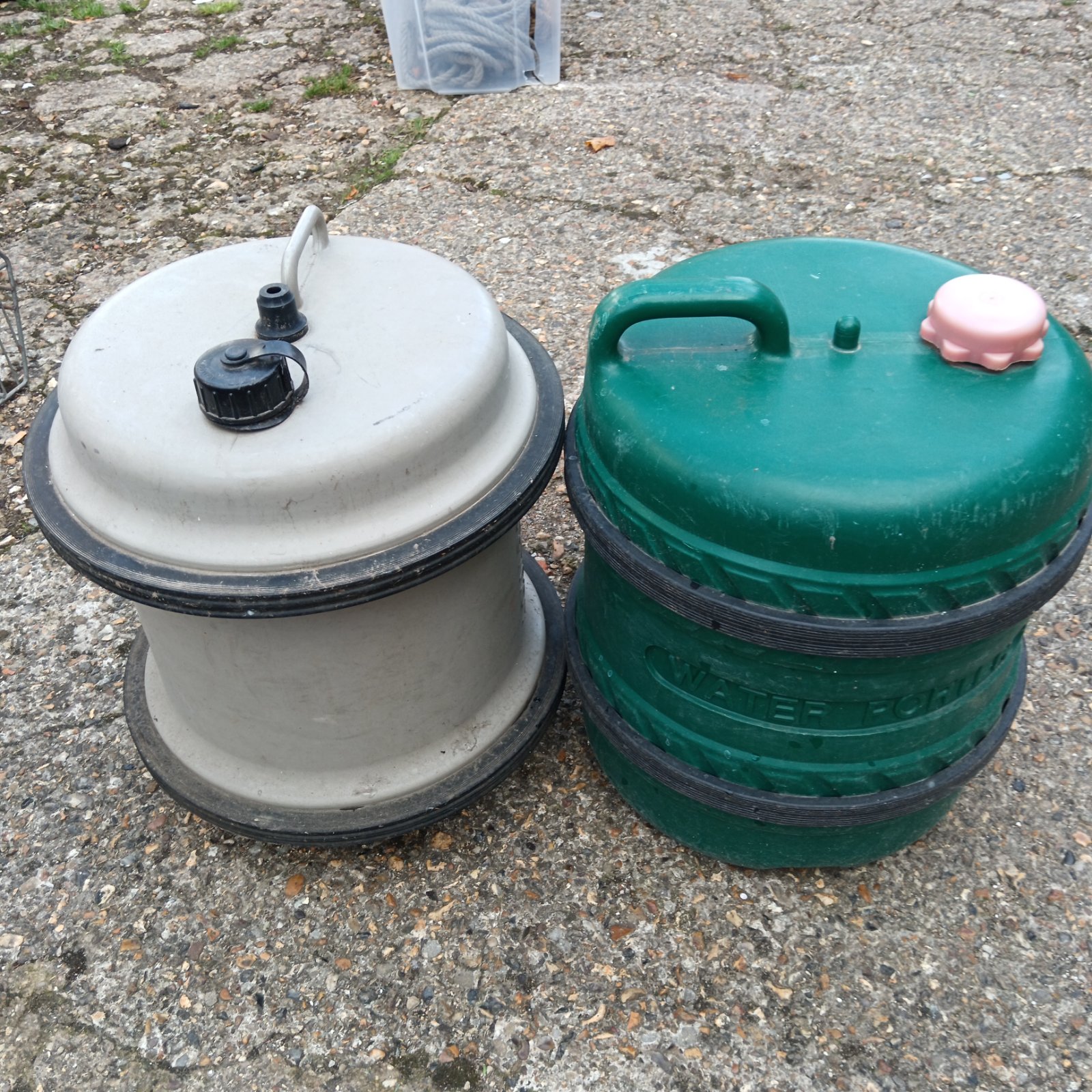 Pair of used caravan water containers for outdoor storage.