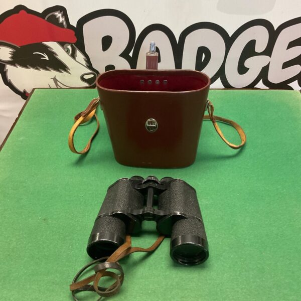 Carlzeiss Jena 10x50 binoculars beside brown leather case with carrying strap