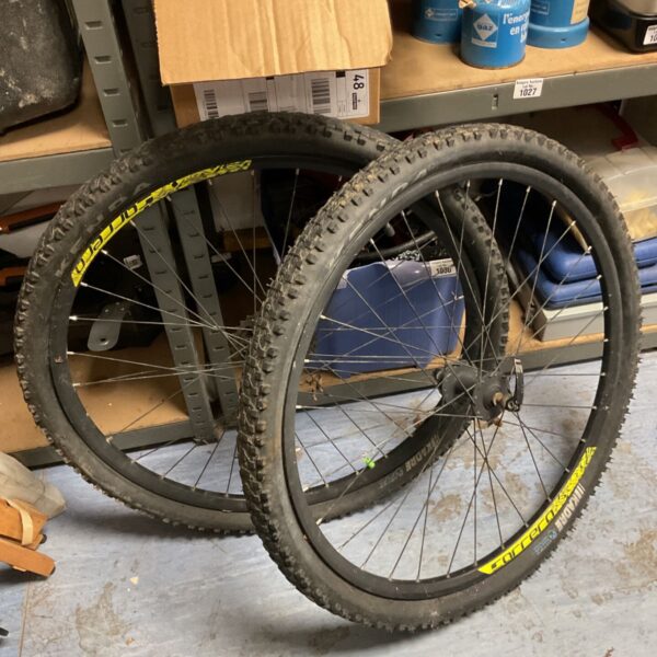Pair of Carrera mountain bike wheels with knobbly tyres and yellow rim decals