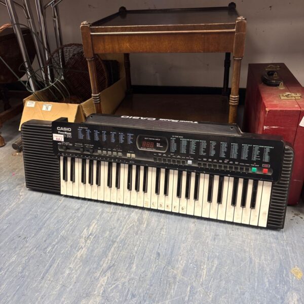 Vintage Casio CT-395 keyboard with keys and controls visible.