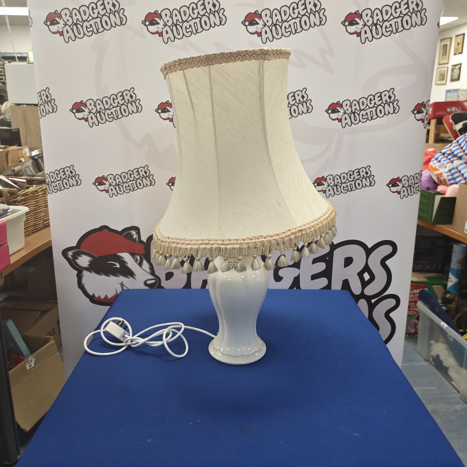 Vintage ceramic table lamp with a cream shade and tassel detail.