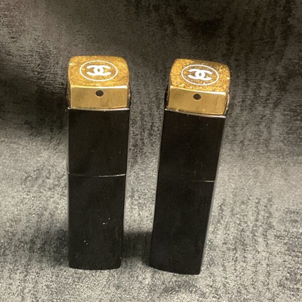Vintage Chanel No5 atomizers in black and gold, collectible perfume bottles.
