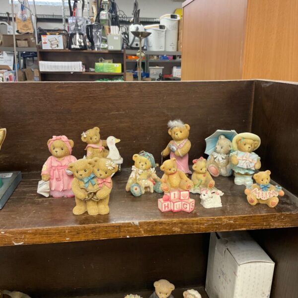 Collection of Cherished Teddies bear figurines displayed on a wooden shelf