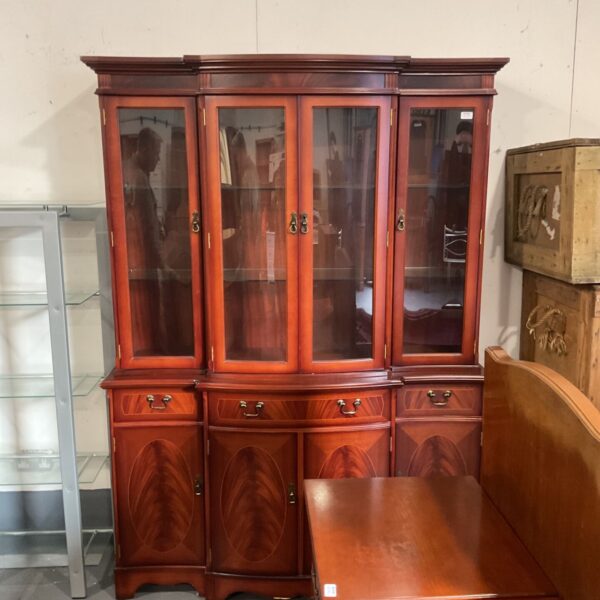 Traditional cherry-finish breakfront china cabinet with glazed doors and brass handles