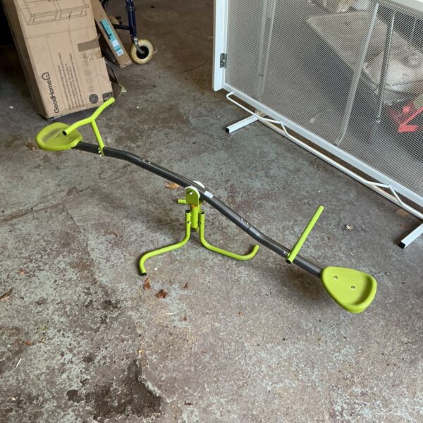 Green children's seesaw with plastic seats and grey tubular bar
