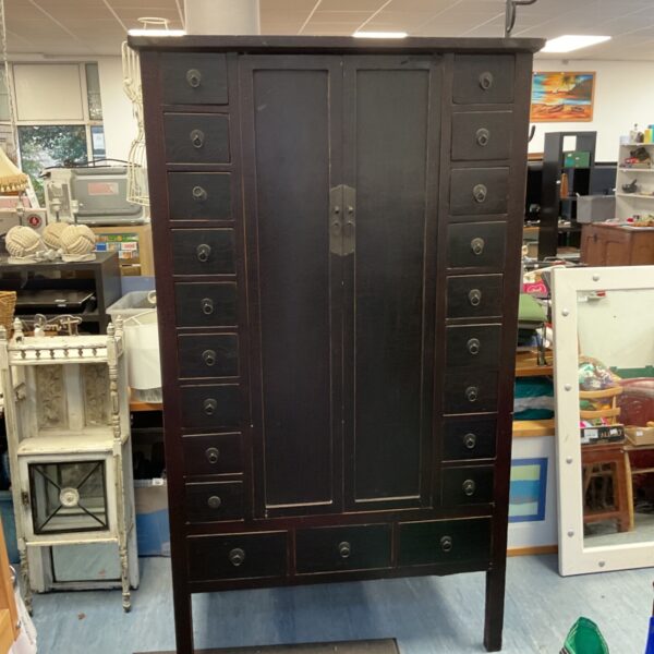 Large black Chinese apothecary cabinet with many drawers.