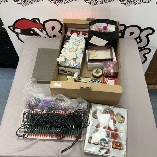 Assorted Christmas decorations including lights and ornaments in a box.
