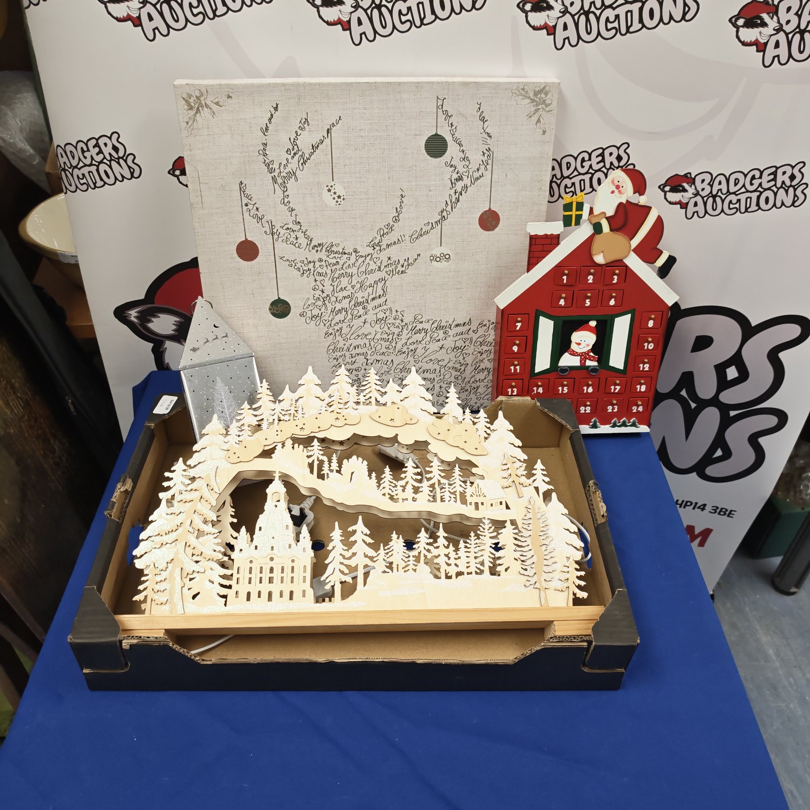 Tray of assorted Christmas decorations including advent calendar and light-up tin.