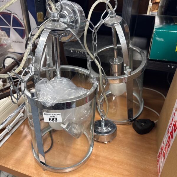 Pair of chrome and glass lantern ceiling lights hanging on chrome chains