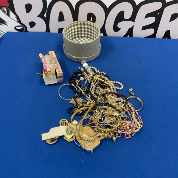 Mixed costume jewellery lot with bead necklaces, gold tone chains and bangles on blue surface