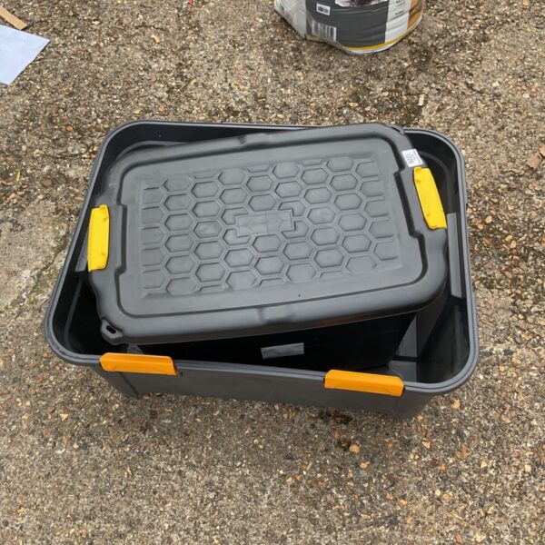Dark grey plastic storage box with lid for household organisation.