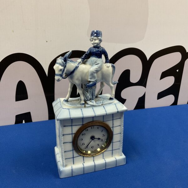 Antique Delft mantle clock with boy on donkey figurine.