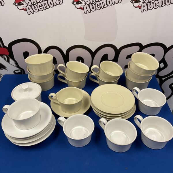 Vintage Denby cups, saucers, and plates set on display.