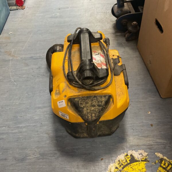 Yellow and black DeWalt corded wet and dry vacuum cleaner on a workshop floor