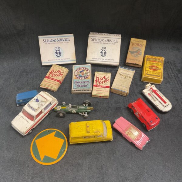 Mixed lot of vintage diecast vehicles and empty cigarette packets.