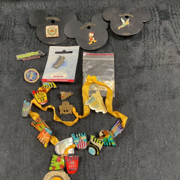 Disney and Euro Disney pin badges on cards with a yellow lanyard of enamel pins